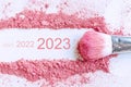 Flat lay of smear of crushed pink blush on as sample of cosmetics product with 2021 2022 2023 number, copy space, top view.