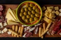 Flat lay of a Spanish tapas plate on a rustic wooden tray  with a variety of cheese, typical meat  and bread Royalty Free Stock Photo