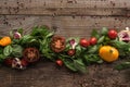 Flat lay with spinach, sliced tomatoes, garlic and scattered pepper on wooden table. Royalty Free Stock Photo