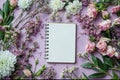 Flat lay of a spiral notebook surrounded in the style of delicate flowers on a pink background, with blank spaces for text or