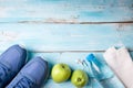 Flat lay sport shoes, bottle of water, apples, towel and earphones on blue wooden background. Healthy lifestyle, sport and diet Royalty Free Stock Photo