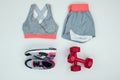 Flat lay with sportswear with sneakers and dumbbells