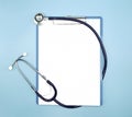 Flat lay of stethoscope and writing pad paper clip board on light blue background with copy space, healthcare and medical concept Royalty Free Stock Photo