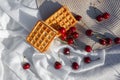 Flat lay, still life and food photo. Cherry and waffle berries lie on a wicker round napkin and crumpled fabric