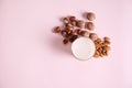 Flat lay glass of healthy nutritious raw vegan plant based milk and assortment of nuts on pink background. Copy ad space