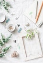 Flat lay still life of homemade crafts work table with accessories - wooden photo frame, flowers, seashells, paper clips, notebook