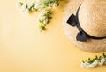 Flat lay a straw hat and a branch with white flowers on a yellow background. Summer vacation concept. Copy space. Royalty Free Stock Photo