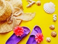 flat lay with straw hat and colorful beach slippers on a yellow background (summer and travel concept) Royalty Free Stock Photo