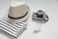Flat lay of a straw hat, a photocamera and a stripped T-shirt. V