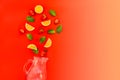 Flat lay Strawberry lemonade ingredients - lemon slices, mint leaves and strawberries falling in a jar on gradient red background. Royalty Free Stock Photo