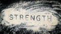 Flat lay of STRENGTH word written on white sand Royalty Free Stock Photo