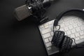 Flat lay, Studio microphone with professional headphones on a PC keyboard. Black on a black background. Podcasts, radio, streams, Royalty Free Stock Photo