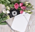 Flat lay style with camera, roses, notebook, earphones and pen