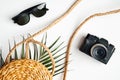 Flat lay stylish summer female fashion outfit and accessories on white background. Top view rattan bag, sunglasses, vintage photo