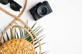 Flat lay stylish traveler accessories with tropical palm leaf branches on white background. Top view woven rattan straw bag, Royalty Free Stock Photo