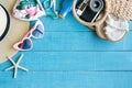 Flat lay of summer accessories with colorful bikini, sunglasses, beach hat, sunscreen, bag, camera and slippers on blue wooden Royalty Free Stock Photo