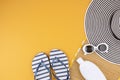 Flat lay with summer accessories for woman. Sun hat, sunglasses, sunscreen protection, flip flops and bag. Summer travel, Royalty Free Stock Photo