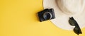 Flat lay summer female fashion straw hat, sunglasses, vintage camera on yellow background. Top view stylish traveler accessories. Royalty Free Stock Photo