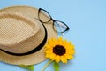 Flat lay with sunglasses, straw boater hat and bright big yellow sunflower on blue background. Travel summer concept. Copy space Royalty Free Stock Photo