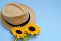 Flat lay with sunglasses, straw boater hat and bright big yellow sunflower on blue background. Travel summer concept. Copy space Royalty Free Stock Photo