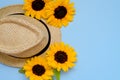 Flat lay with sunglasses, straw boater hat and bright big yellow sunflower on blue background. Travel summer concept. Copy space Royalty Free Stock Photo