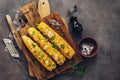 Flat lay sweet corn grilled with cheese, cilantro and spices on a rustic cutting board. Vegan or vegetarian dinner or snack. Top