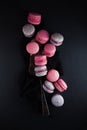 Flat-lay of sweet pink, violet french macaroon cookies on black slate plate Royalty Free Stock Photo