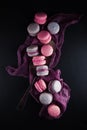 Flat-lay of sweet pink, violet french macaroon cookies on black slate plate Royalty Free Stock Photo