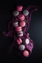 Flat-lay of sweet pink, violet french macaroon cookies on black slate plate Royalty Free Stock Photo