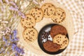 Flat lay of sweets, Chocolate chip cookies on black plate and rattan plate over brown gingham cloth Royalty Free Stock Photo