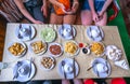 Flat lay table with tofu, fried eggs, spring rolls, mixed noodles, starters and pastries over yellow table cloth