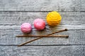 Three colored wool balls, knitting needles on the wooden background Royalty Free Stock Photo