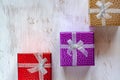 Flat lay.  Three gift boxes with bows on a white surface painted with a brush. Royalty Free Stock Photo