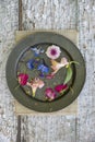 Flat lay top down view image of romantic vintage look of Spring and Summer flower petals and blooms still life on rustic old worn