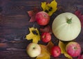Flat lay, top view autumn harvest composition, ripe vegetables and fruits, apples, zucchini, colorful leaves on a dark wooden