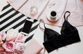Flat lay. Top view black lace lingerie. Beauty blog concept. Bouquet of roses and pions, coffee on white background Royalty Free Stock Photo