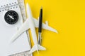 Flat lay or top view of black pen, miniature airplane, compass,