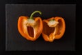 Flat lay. Close up, macro. A fleshy juicy bell pepper cut in half. Black background Royalty Free Stock Photo