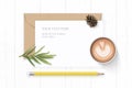 Flat lay top view elegant white composition letter kraft paper envelope pine cone yellow pencil tarragon leaf and coffee on wooden