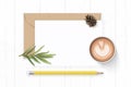 Flat lay top view elegant white composition letter kraft paper envelope pine cone yellow pencil tarragon leaf and coffee on wooden