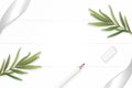 Flat lay top view elegant white composition silver ribbon pencil eraser tarragon leaf on wooden floor background