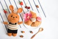 Flat lay, top view, food and beverage in white background, cute crochet brown bunny eating healthy breakfast meal with croissants,