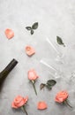 Flat lay top view golden wedding rings with roses and champagne glasses on grey concrete background