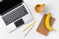 Flat lay top view modern laptop, food and stationery on white table