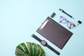 Flat lay top view modern office desk Workspace with blank clip board, eye glasses, office supplies, pen,watches,green leaf coffee Royalty Free Stock Photo