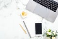 Flat lay, top view modern office table desk. Workspace with laptop computer, smartphone with blank screen, diary, flowers and Royalty Free Stock Photo