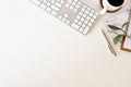 Flat lay top view office desk. Workspace with keyboard and office supplies, pencil, green leaf with coffee on white background.