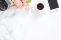 Flat lay, top view office table desk. Feminine desk workspace frame with coffee cup, floral bouquet, smartphone and stationery on