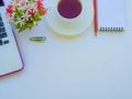 Office accessories including laptop, note book, red pencil, coffee cup, calculator and flower on white background. Royalty Free Stock Photo