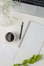 Workspace with blank clip board, laptop, office supplies, pencil, green leaf, and coffee cup on white background Royalty Free Stock Photo